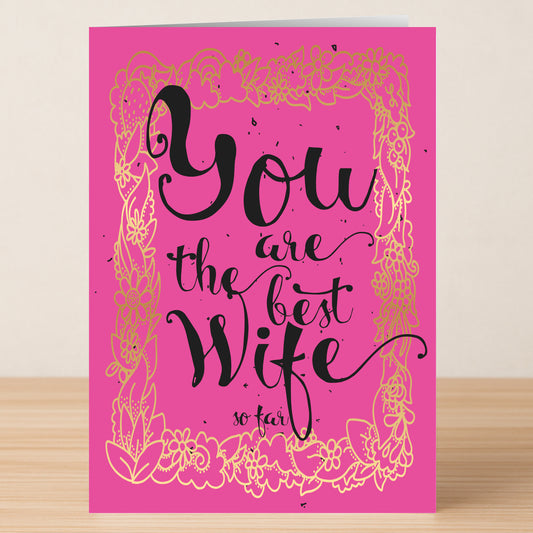 The So Far Funny Greeting Card by Twisted Gifts features a pink design with a gold floral border and the witty message, "You are the best wife so far." Perfect for sharing humor with your loved one this Valentine’s Day.
