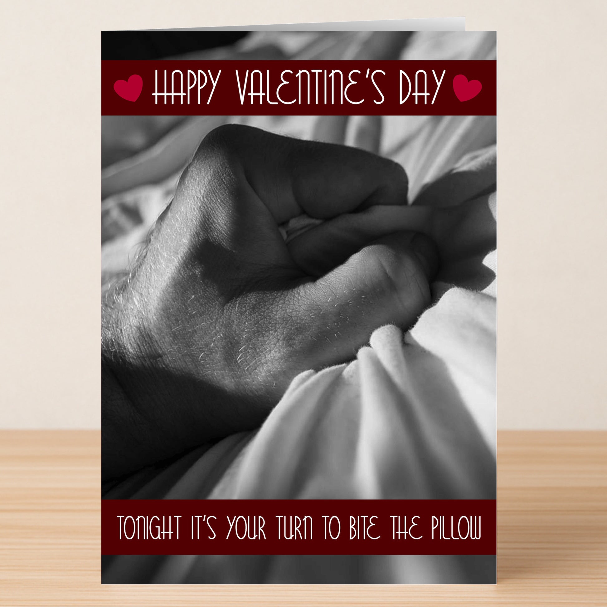 The Pillow Rude Valentine's Card by Twisted Gifts features a grayscale hand gripping a bedsheet with the cheeky message "Tonight it’s your turn to bite the pillow." A hilariously bold card for quirky Valentine’s Day wishes!.