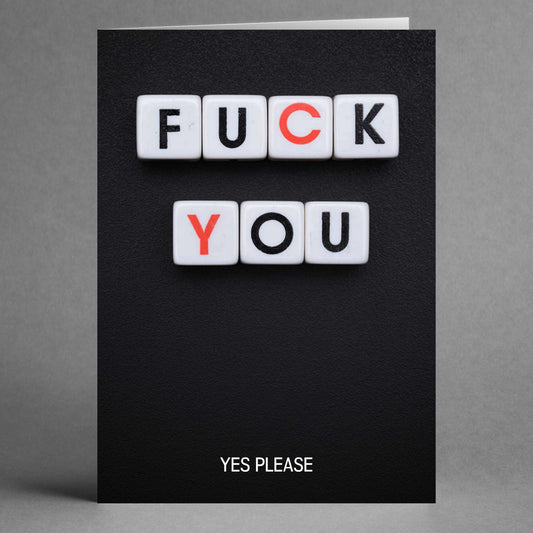 Twisted Gifts presents the "Yes Please Rude Valentine's Card," featuring tiles that boldly spell "FUCK YOU" in uppercase letters on a black background, with a humorous touch below that reads "YES PLEASE" in smaller letters.