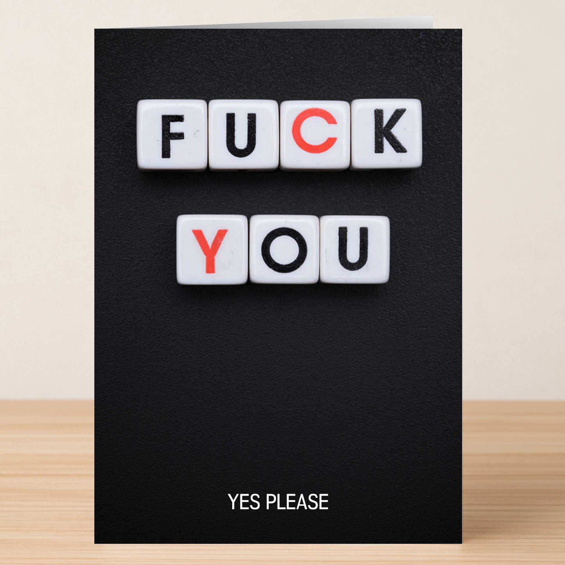 The Yes Please Rude Valentine’s Card by Twisted Gifts is a black card with white tiles spelling "FUCK YOU" in bold letters and "YES PLEASE" in small text below—a cheeky, funny way to surprise someone special.