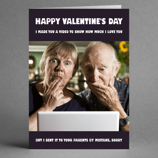 A couple looks surprised at a laptop screen on the Mistake Funny Valentine's Card by Twisted Gifts, featuring a hilarious message about accidentally sending a romantic video to parents.