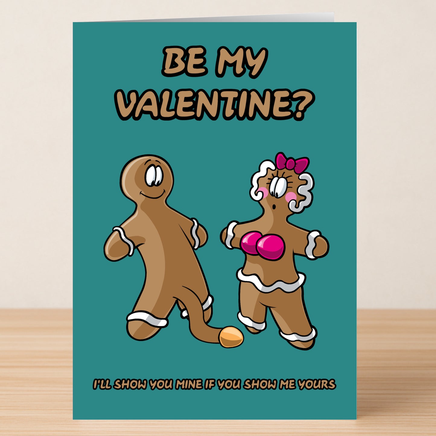 The Show Me Yours Rude Valentine’s Card by Twisted Gifts features cartoon gingerbread figures and the cheeky message, “Be My Valentine? I’ll show you mine if you show me yours.”.