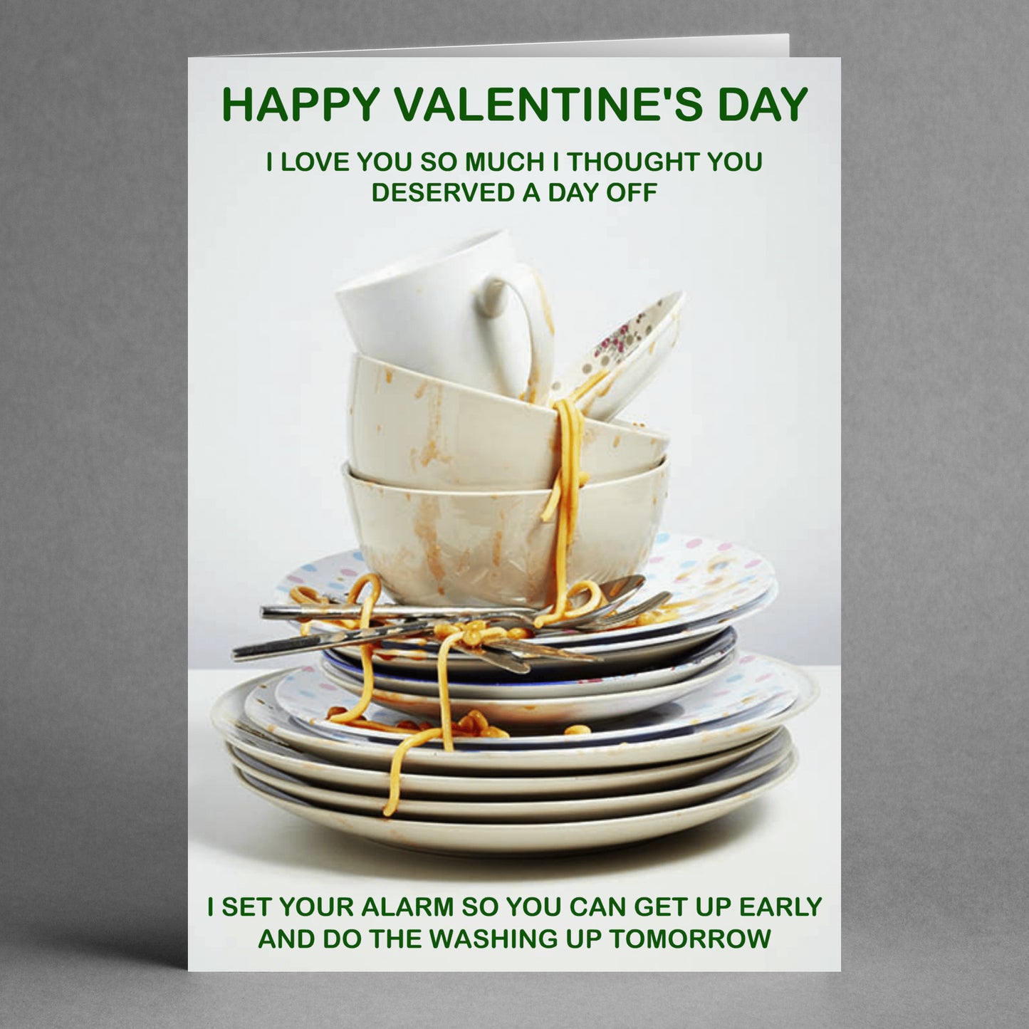 The Get Up Early Funny Valentine's Card by Twisted Gifts amusingly illustrates a pile of dirty dishes with a clever joke about taking just one day off while still setting the alarm to conquer the dishwashing marathon the next day.