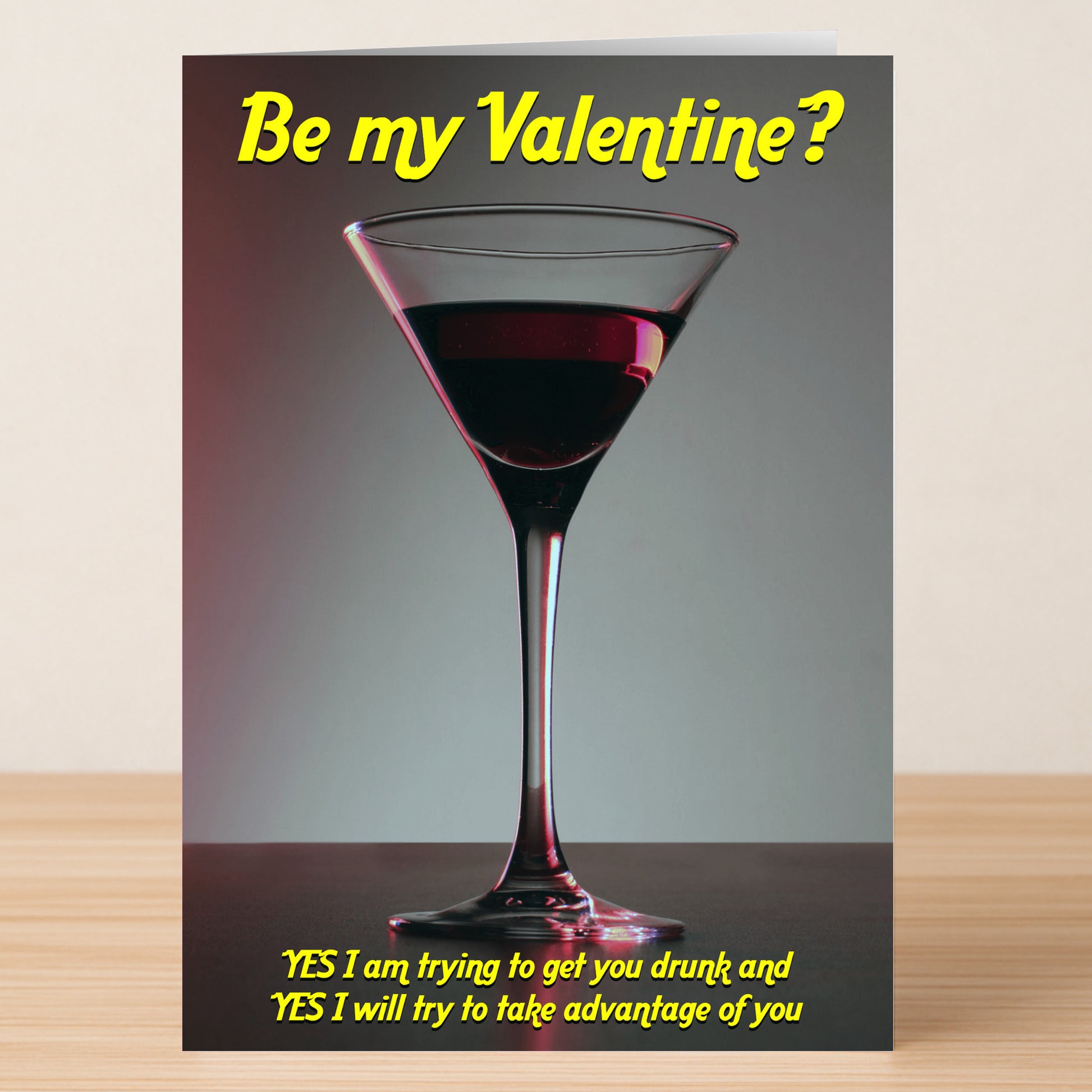 The Get You Drunk Her Rude Valentine's Card by Twisted Gifts shows a martini glass with red liquid, "Be my Valentine?" above, and a cheeky yellow message below—all in a playful style.