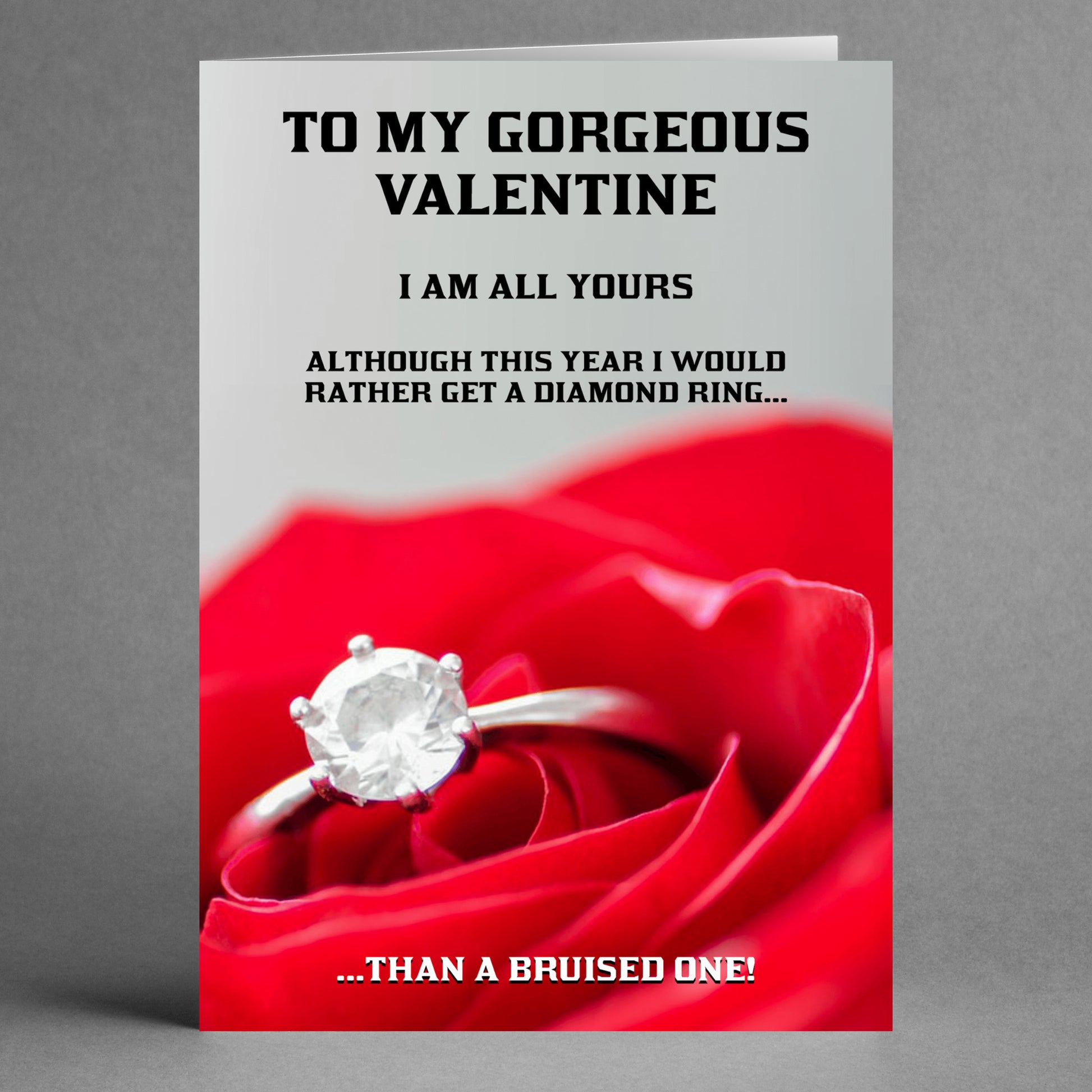 A Twisted Gifts card called the "Diamond Ring Rude Valentine's Card," showcases a diamond ring resting on a red rose. It includes the message: "To my gorgeous valentine, I'm all yours, but this year I'd prefer a diamond in the rough...than a bruised one!