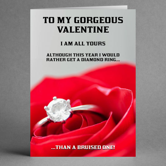 A Twisted Gifts card called the "Diamond Ring Rude Valentine's Card," showcases a diamond ring resting on a red rose. It includes the message: "To my gorgeous valentine, I'm all yours, but this year I'd prefer a diamond in the rough...than a bruised one!