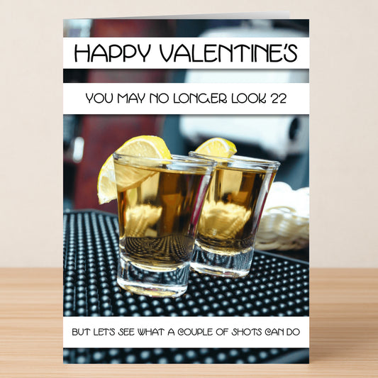 Two shot glasses with lemon slices sit on a bar mat, featuring the “Couple Of Shots Insulting Valentine’s Card” by Twisted Gifts—perfect for those who love humor and a cheeky Valentine’s surprise.