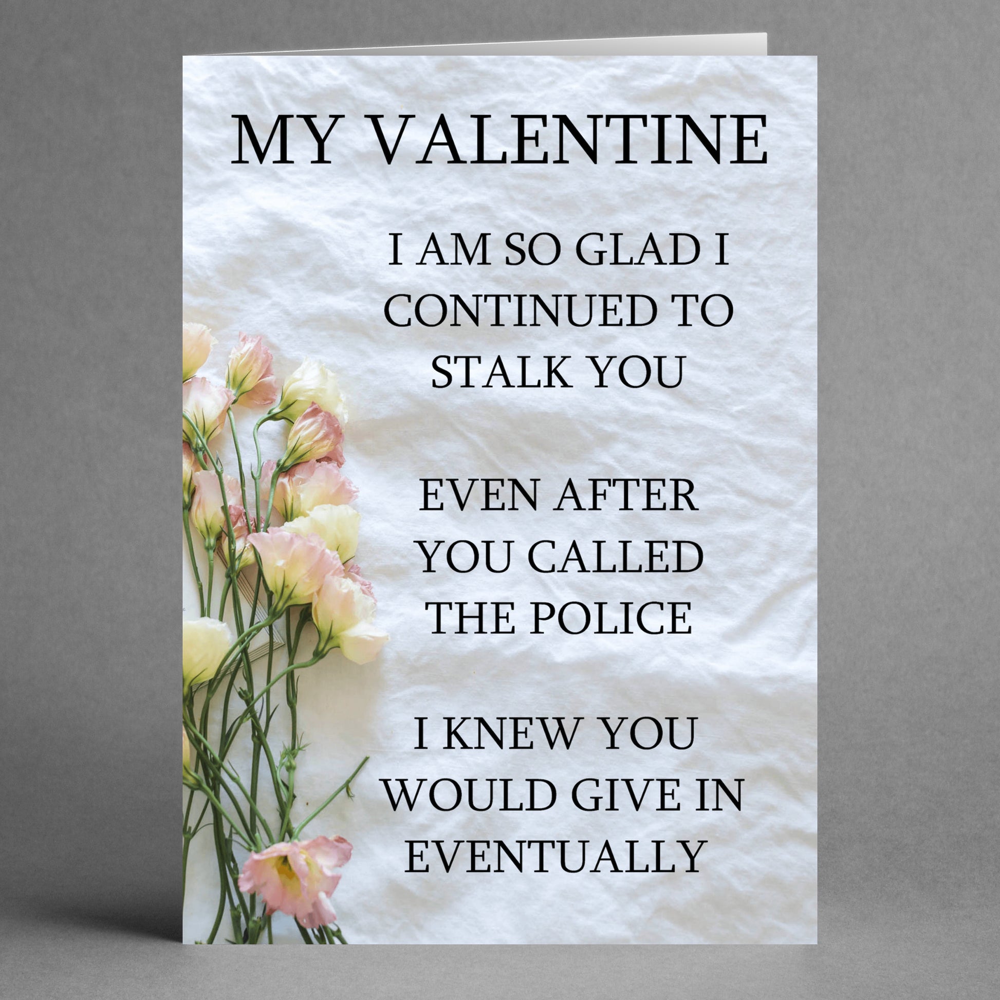 The "Stalk Insulting Valentine's Card" by Twisted Gifts offers a unique twist on romance with its non-traditional design, featuring flowers on the left side and humorous, stalker-themed text about relationships on the right.