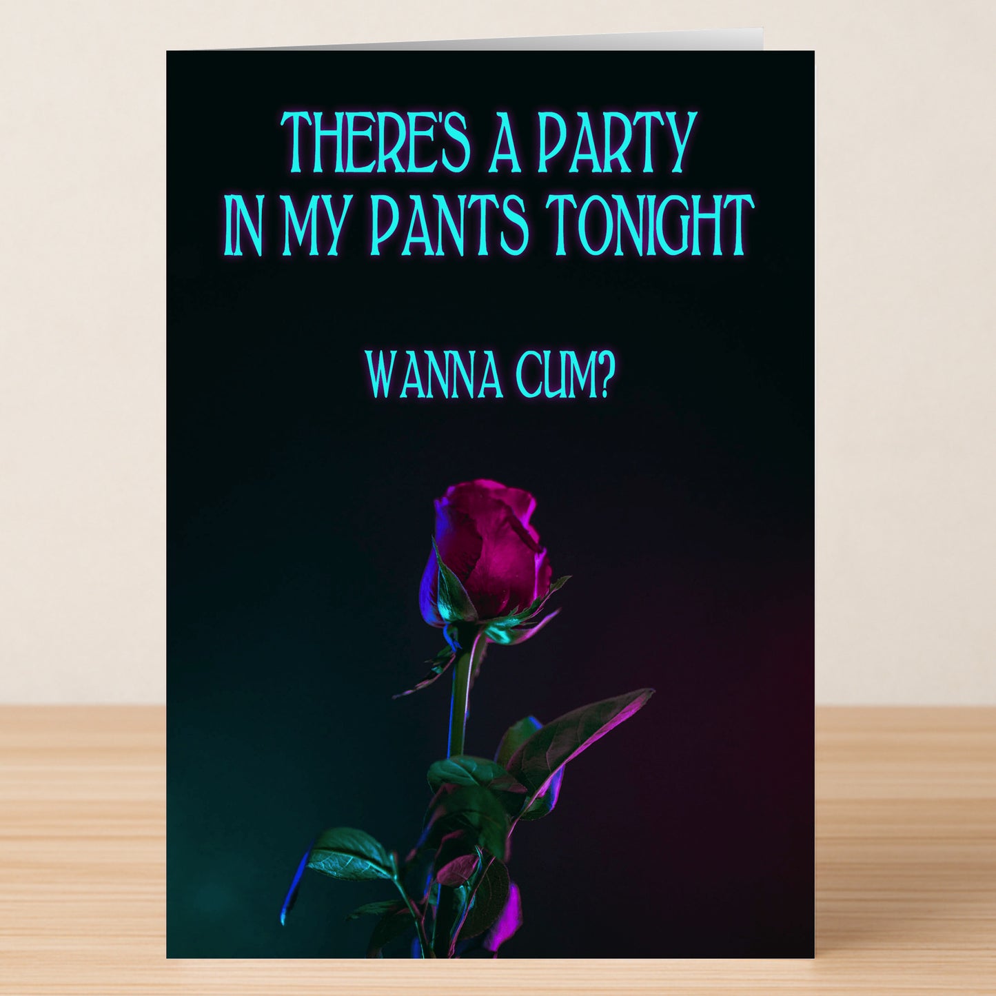 The Party Pants Rude Greeting Card by Twisted Gifts features the cheeky message, "There's a party in my pants tonight. Wanna cum?" above a single dark purple rose on wood, set against a black background.