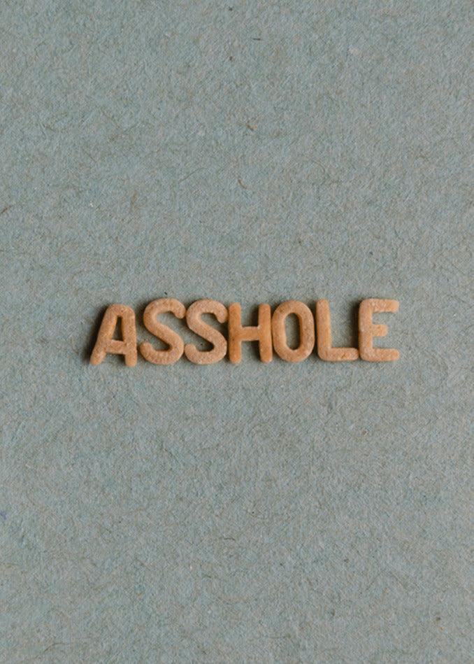 A hilariously twisted gift of a wooden word with the term "Asshole Insulting Greeting Card" by Twisted Gifts on it, perfect as a funny greeting card.