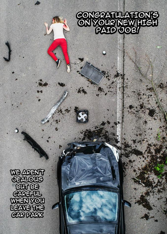 A woman is laying on the ground next to a wrecked car, in need of immediate medical attention, holding a Twisted Gifts High Paid Job Funny Congratulations Card.