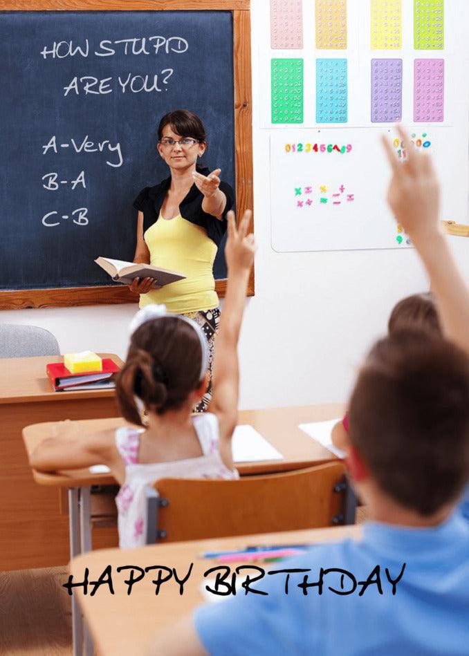 A woman in a classroom with children in front of a chalkboard, creating a gigglesome atmosphere with Twisted Gifts' How Stupid Insulting Birthday Card.