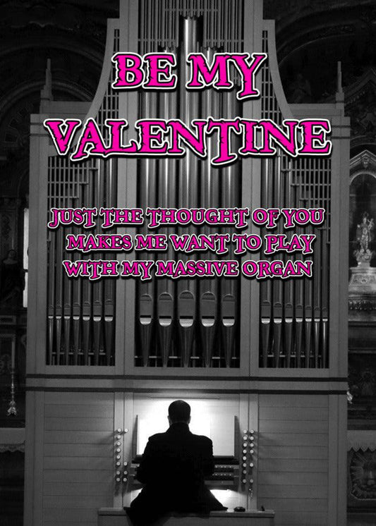 A man sitting in front of an organ, smiling and holding a Twisted Gifts Organ Rude Valentine's Card.