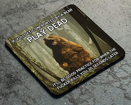A Play Dead Coaster by Twisted Gifts with a bear in the woods.