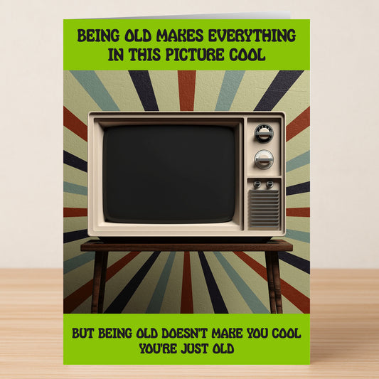 The Old Is Cool – Funny Birthday Card by Twisted Gifts features a retro TV on a wooden table with a vibrant backdrop and witty text, blending humor and nostalgia for a playful take on getting older.
