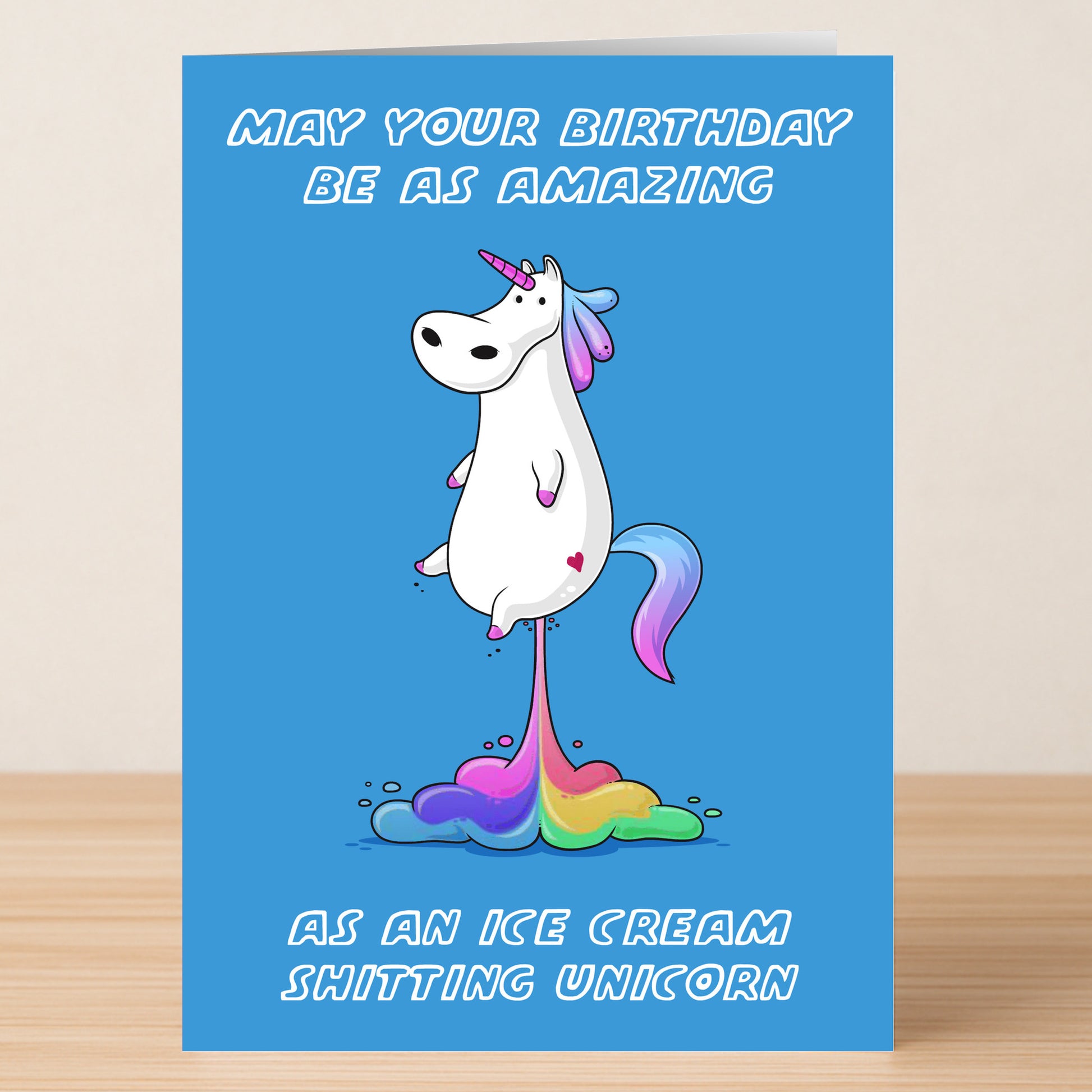 The Unicorn – Funny Birthday Card by Twisted Gifts features a cartoon unicorn pooping rainbow ice cream and the cheeky text: “May your birthday be as amazing as an ice cream shitting unicorn.” Ideal for fans of rude humor!.