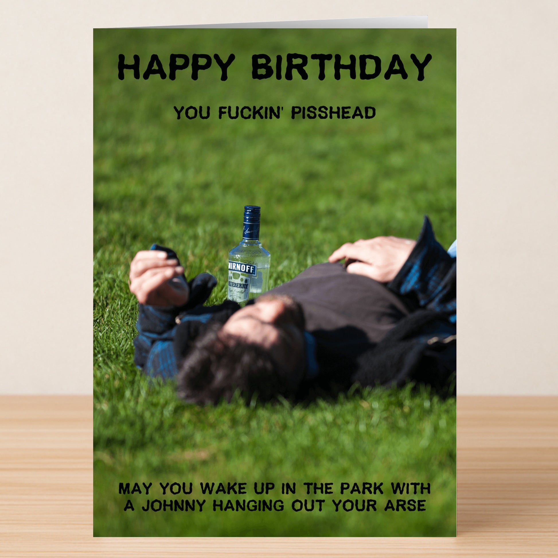 The Pisshead – Rude Birthday Card by Twisted Gifts shows a person lying on grass next to a vodka bottle, with bold, vulgar birthday wishes—perfect for anyone who loves funny, rude cards.