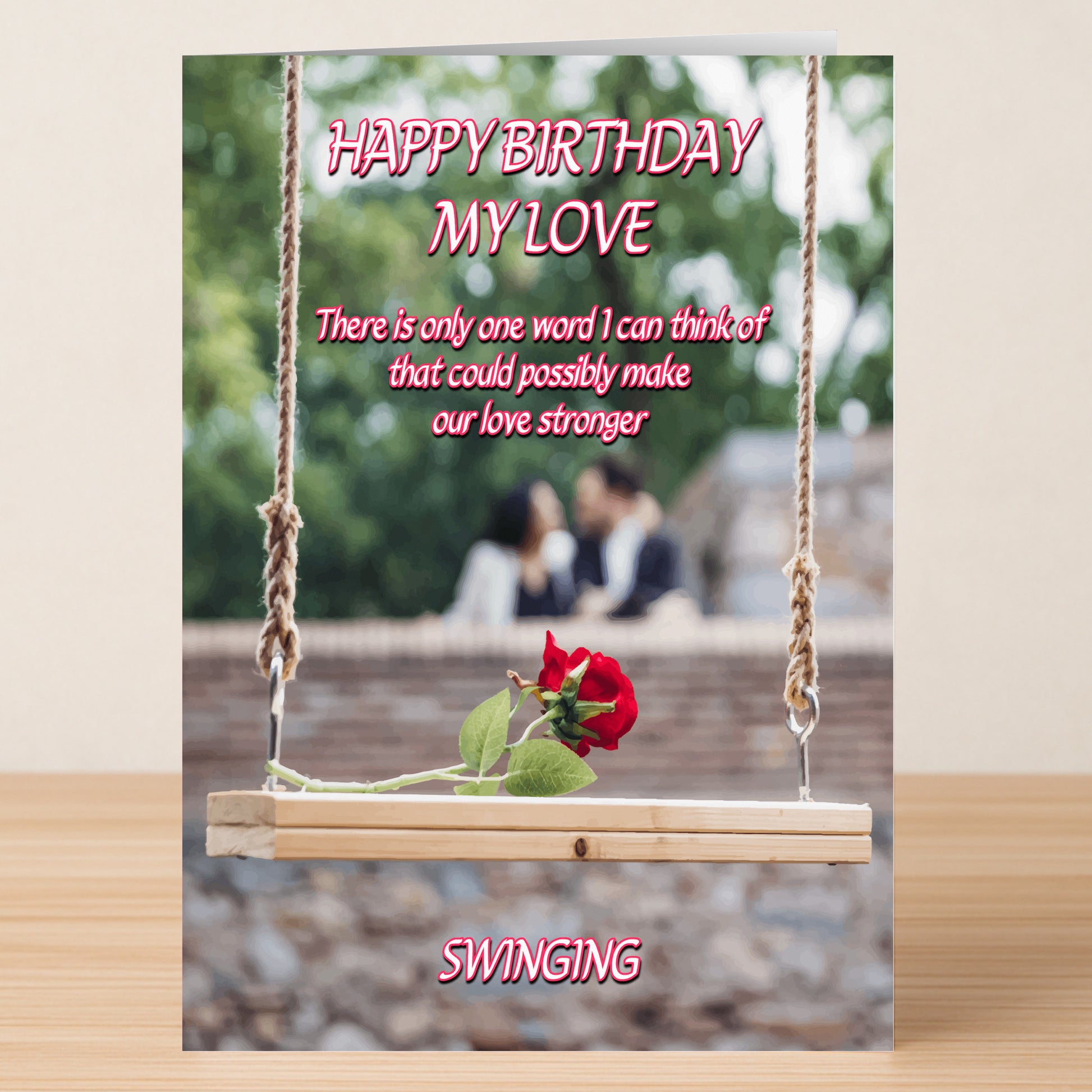 Swinging – Rude Birthday Card by Twisted Gifts: A humorous birthday card with a wooden swing holding two red roses, a blurred couple in the background, and playful text about love and swinging.