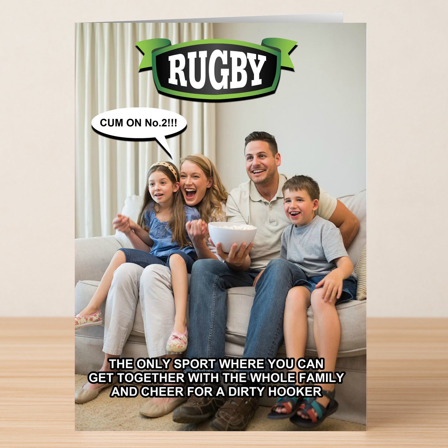 A family of four cheers for rugby on TV with the caption: "Twisted Gifts Hooker – Rude Birthday Card: The only sport where you can cheer for a dirty hooker! Perfect for an offensive birthday surprise.
