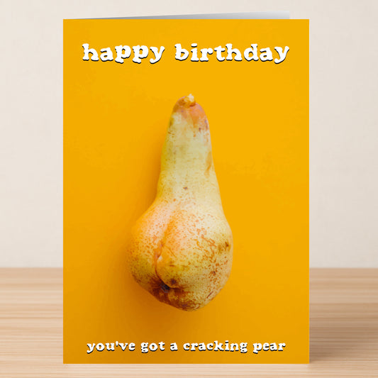 The Cracking Pear – Funny Birthday Card by Twisted Gifts features a pear resembling buttocks on yellow, with "happy birthday" at the top and "you've got a cracking pear" below—a cheeky, rude card for someone with a sense of humor.