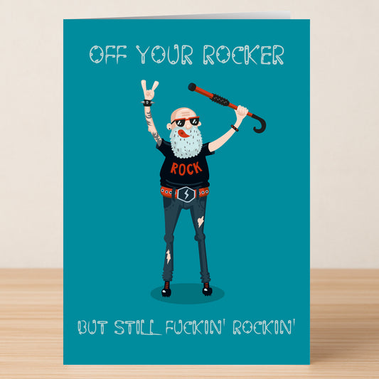 An illustrated older man with a cane, dressed in rock attire, stands between "OFF YOUR ROCKER" and "BUT STILL FUCKIN' ROCKIN'"—a humorous Twisted Gifts Rocker Funny Birthday Card for any music lover.
