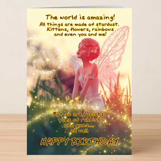 The Star Dust – Funny Birthday Card by Twisted Gifts features a fairy figurine amid glowing lights and whimsical text about the world’s wonders and flaws, ending with "HAPPY BIRTHDAY.