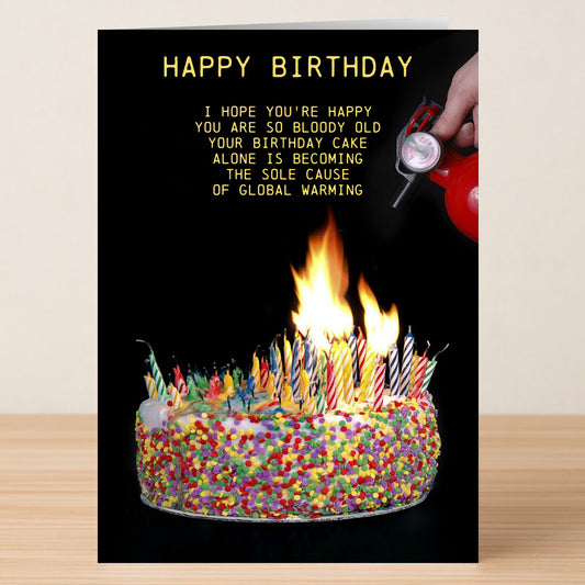The Twisted Gifts Candles – Insulting Birthday Card features a cake ablaze with candles and a hand reaching for a fire extinguisher, with a joke about global warming—ideal for anyone who enjoys cheeky birthday humor!.