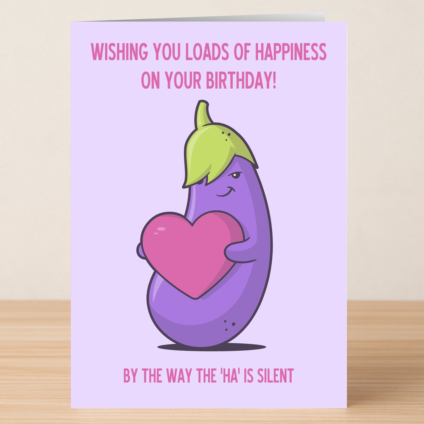 The Silent HA – Rude Birthday Card from Twisted Gifts features a cartoon eggplant with a pink heart and the witty message, "Wishing you loads of happiness on your birthday! By the way, the 'ha' is silent.