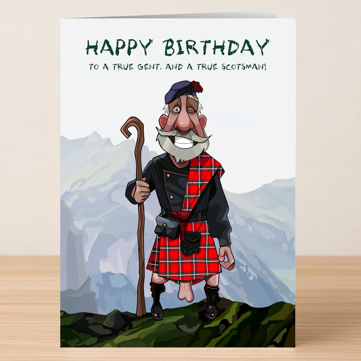 The Scotsman – Rude Birthday Card by Twisted Gifts features a cartoon older man in a tartan kilt and tam, holding a shepherd's crook with mountains behind, making it a funny birthday greeting.