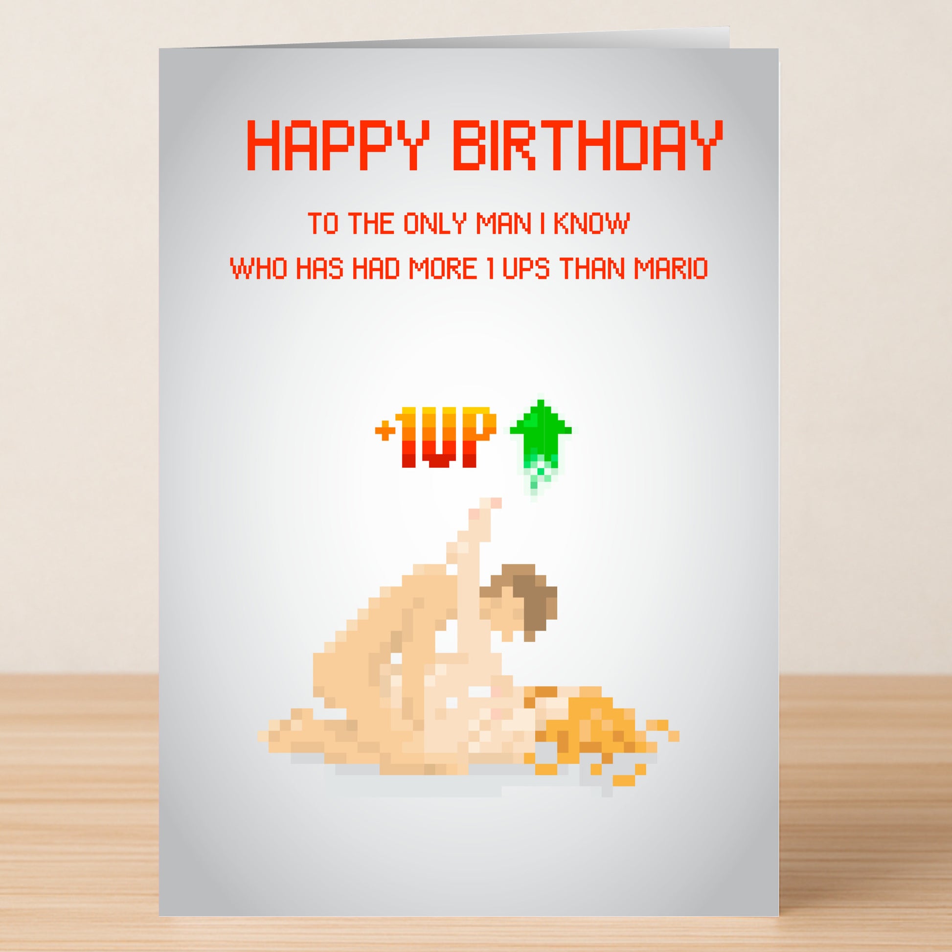 The 1 Up Man Rude Birthday Card by Twisted Gifts features pixel art of two nude figures and the text: “HAPPY BIRTHDAY to the only 1 Up Man I know who’s had more 1 ups than Mario +1UP.” Ideal for fans of cheeky birthday cards.