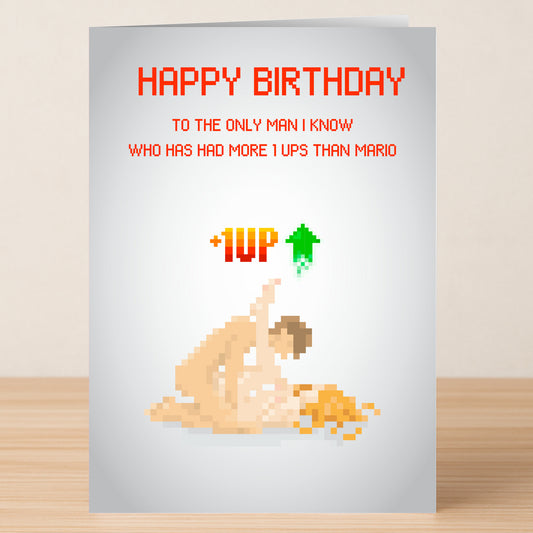 The 1 Up Man Rude Birthday Card by Twisted Gifts features pixel art of two nude figures and the text: “HAPPY BIRTHDAY to the only 1 Up Man I know who’s had more 1 ups than Mario +1UP.” Ideal for fans of cheeky birthday cards.
