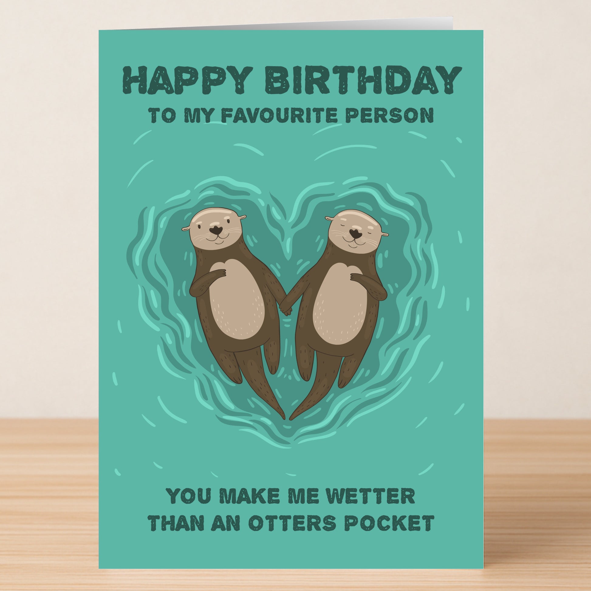The Otter’s Pocket – Rude Birthday Card by Twisted Gifts features two otters holding hands in a heart-shaped ripple, with the cheeky message: "Happy Birthday to my favourite person. You make me wetter than an otter's pocket.