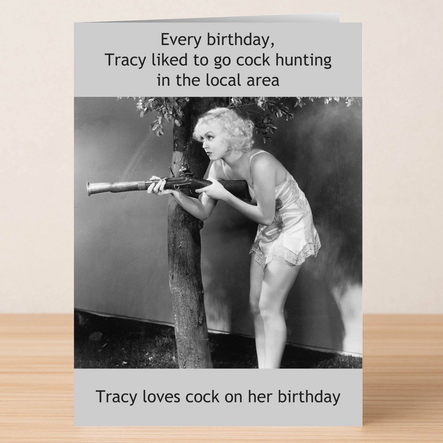 The Tracey Loves Cock – Rude Birthday Card by Twisted Gifts features a cheeky black-and-white photo of a woman in a short nightgown crouching with a rifle and bold, funny text for some offensively humorous birthday fun.