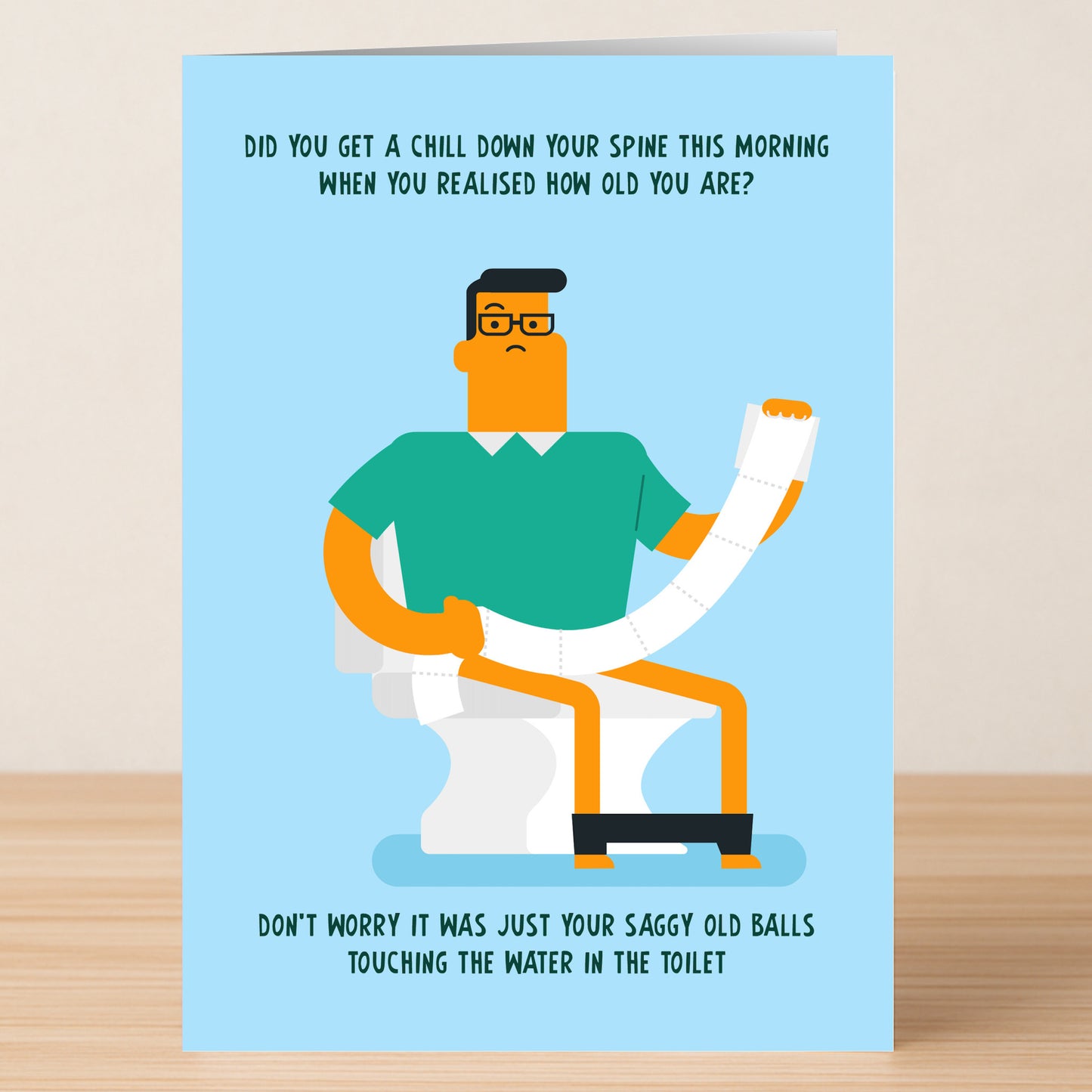 Saggy Balls – Funny Birthday Card by Twisted Gifts features a man on a toilet holding a long roll of toilet paper, with hilarious aging jokes above and below—perfect for anyone with a cheeky sense of humor.