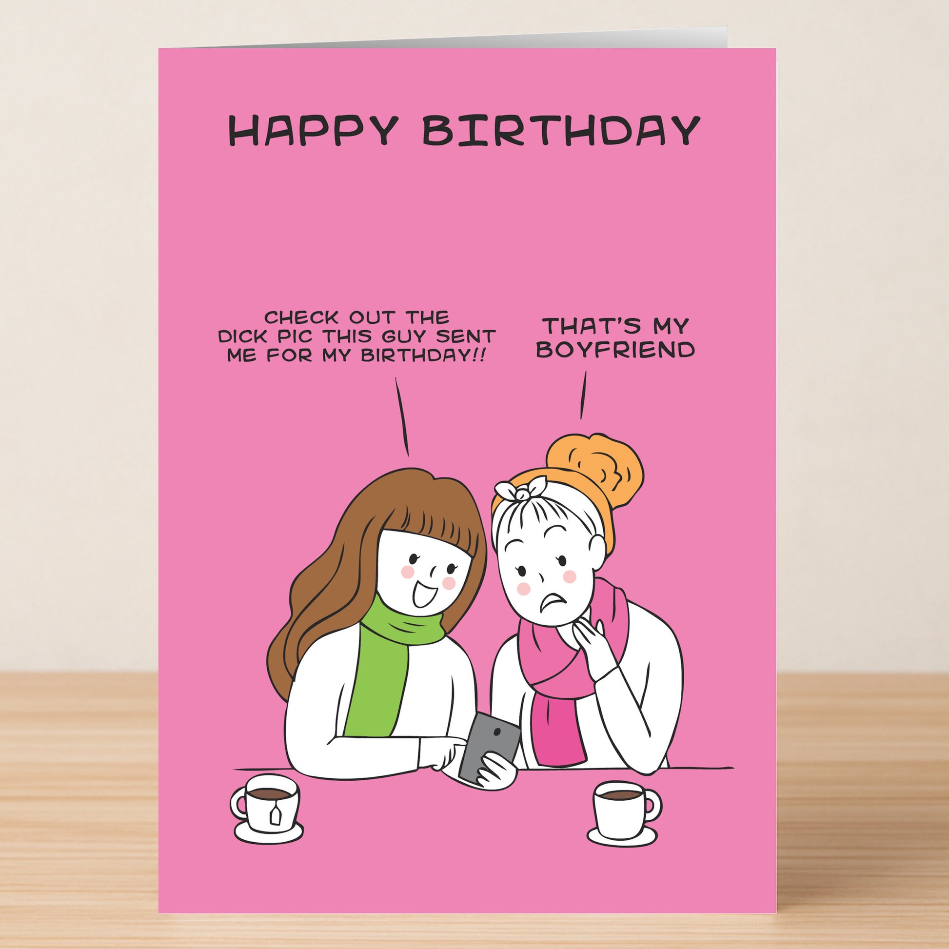 Twisted Gifts’ "Birthday Pic – Rude Birthday Card" features a cartoon of two women at coffee: one shows her new phone, saying it's a birthday gift from a guy. The other answers, "That's my boyfriend." Perfect for fans of awkward humor!.