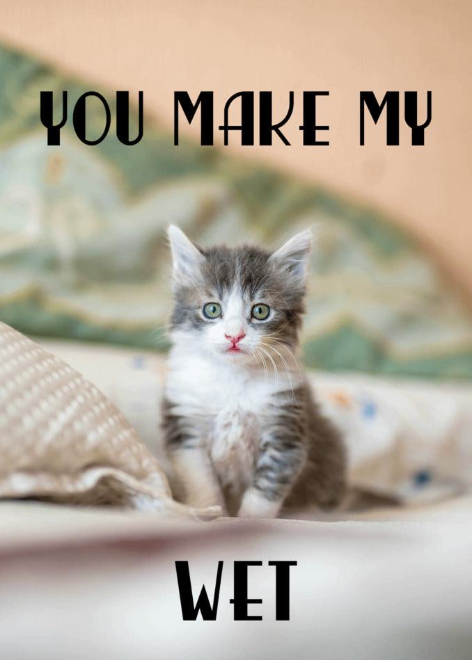 A kitten sitting on a bed with a Twisted Gifts Wet Rude Valentine's Card.